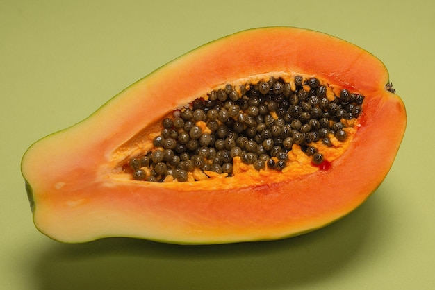Zdjęcie owoce papai na zielonym tle. owoc tropikalny. połowa papai.
