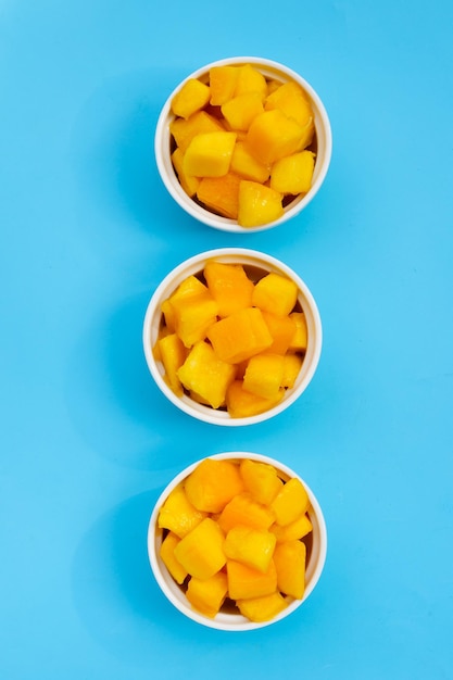 Owoce Tropikalne, Plastry Kostki Mango W Białych Filiżankach Na Niebieskim Tle.