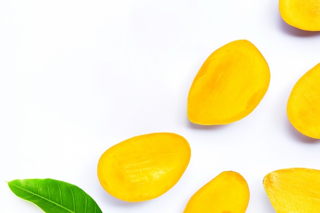 Owoce tropikalne, plastry mango z liściem na białym tle.