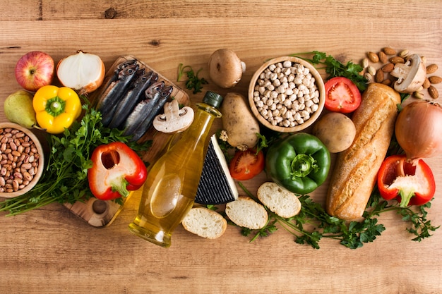 Owoce, warzywa, zboże, orzechy, oliwa z oliwek i ryby na drewnianym stole