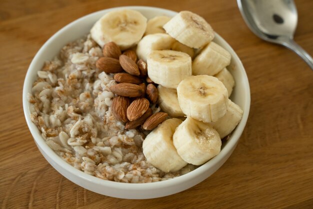 Zdjęcie owoce z bananowym miodem i migdałami na śniadanie na stole