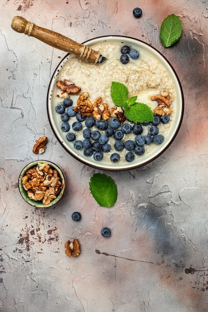 Zdjęcie owsianka z dojrzałymi jagodami na zdrowe śniadanie na rustykalnej drewnianej desce z bliska detox i koncepcja zdrowej miski pożywienia