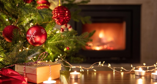 Ozdoba choinkowa i prezenty świąteczne na tle płonącego kominka