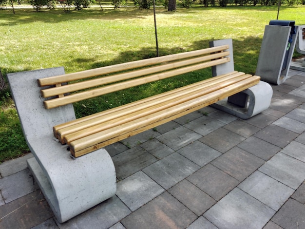 Ozdobna pusta ławka z drewna i betonu na ulicy w miejskim parku