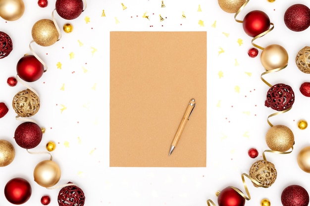 Ozdoby noworoczne i świąteczne oraz pusty arkusz papieru i długopis.