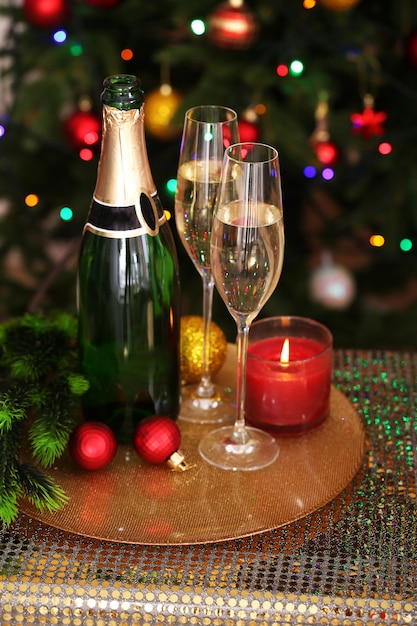 Ozdoby świąteczne i butelka szampana i kieliszki na jasnym tle