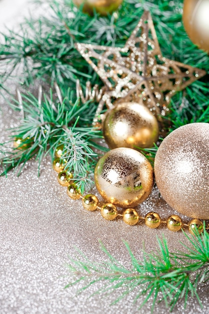 Ozdoby świąteczne i zbliżenie gałęzi jodły wiecznie na złoty brokat.