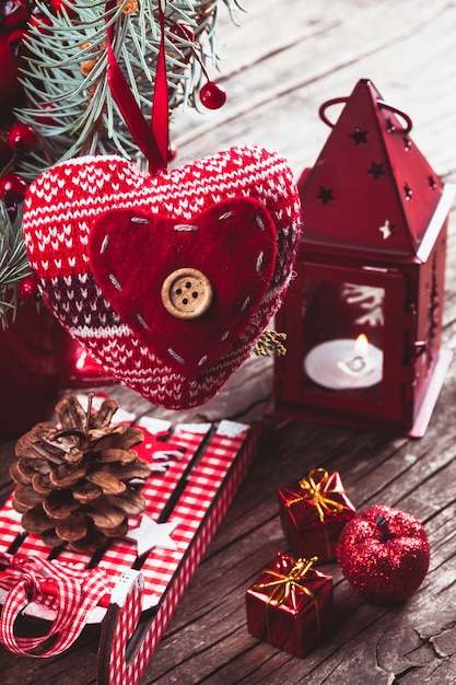 Ozdoby świąteczne: serce, świecznik i sanki na starym drewnianym stole