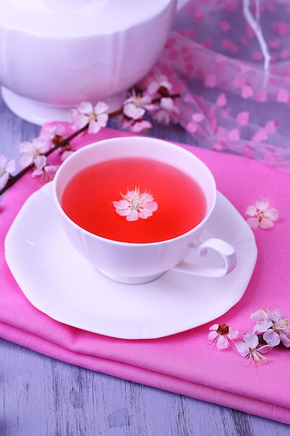 Pachnąca herbata z kwitnącymi gałęziami na drewnianym stołowym zbliżeniu