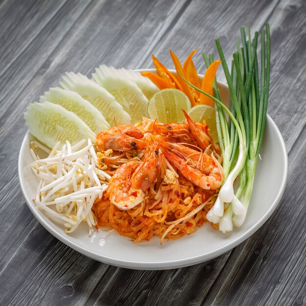 Pad Thai, Pud Thai smażony makaron z krewetkami podany z kiełkami fasoli mung, ogórkiem, limonką, chilli i szczypiorkiem