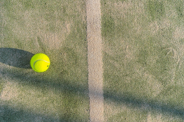 Paddle piłka tenisowa na korcie z siatką w tle i pięknym światłem słonecznym