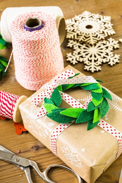 Zdjęcie pakowanie prezentów świątecznych w brązowy papier z recyklingu w stylu vintage w domu.