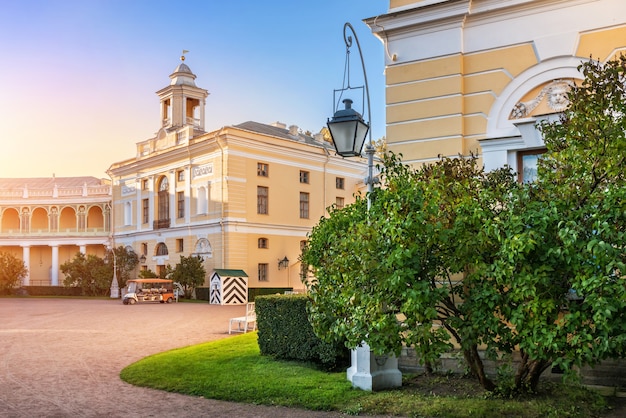 Pałac w Pawłowsku w Petersburgu, oświetlony jesiennym słońcem i lampą przy krzakach bzu