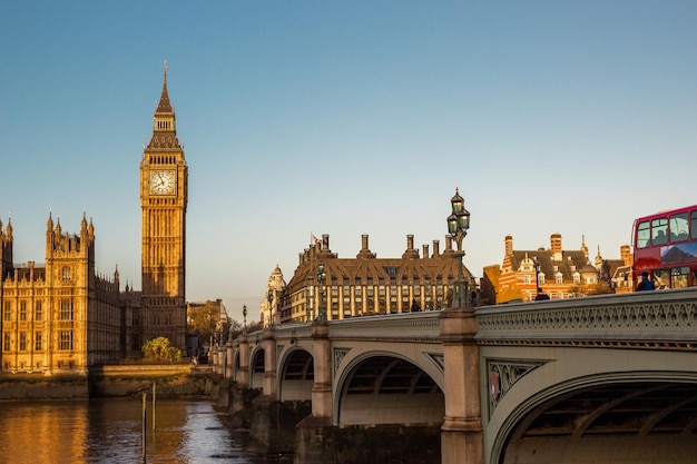 Zdjęcie pałac westminsterski i big ben wzdłuż tamizy z mostem westminster w londynie w anglii