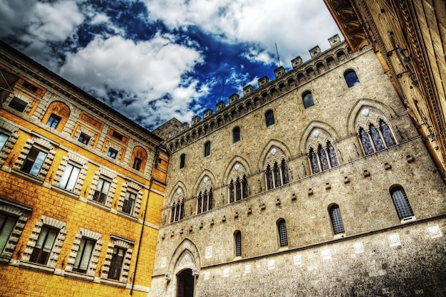 Pałace Salimbeni i Tantucci w Sienie pod zachmurzonym niebem