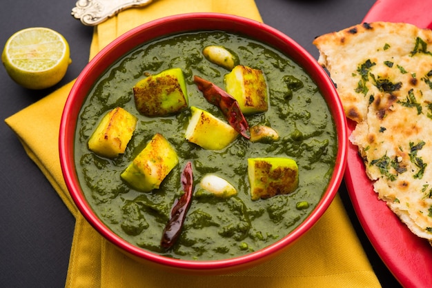 Palak Paneer Curry składające się ze szpinaku i twarogu, popularne indyjskie zdrowe menu na lunch lub kolację, podawane w karahi z Roti lub Chapati na nastrojowym tle. selektywne skupienie