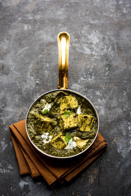 Zdjęcie palak paneer curry ze szpinaku i twarogu podawane w misce lub patelni z roti lub ryżem