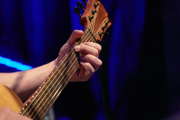 Zdjęcie palce grające akord na gryfie gitary akustycznej