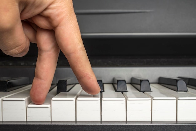 Palce stukają w klawisze fortepianu, jakby chodziły nogi