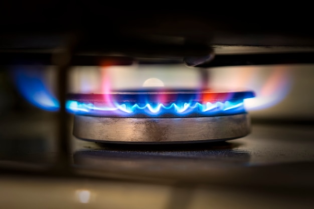Palnik gazowy na kuchence. Selektywne skupienie. Niebieski gaz propan pali się na kuchence gazowej w kuchni. konsumencki gaz ziemny