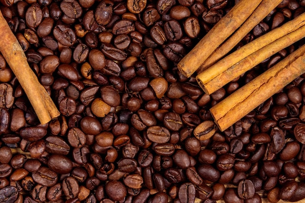 Palone ziarna kawy i cynamonu na rustykalne drewniane tła. Widok z góry