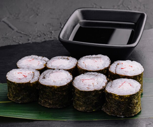 Zdjęcie paluszek krabowy maki sushi na czarnej tacy