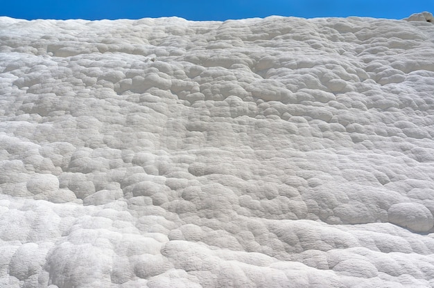 Pamukkale, Bawełniany Zamek, Cud Natury Tworzą Warstwy Białego Trawertynu Przypominające Bawełnę, Turcja. Naturalna ściana Pamukkale Na Tle Błękitnego Nieba