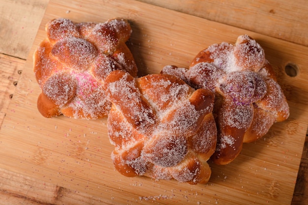 Pan de muertos na drewnianym stole. Typowy meksykański deser na Dzień Zmarłych. Widok z góry.