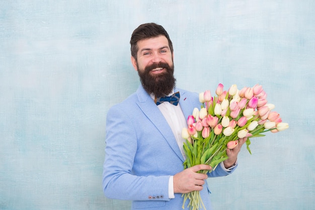 Pan młody na weselu brodaty mężczyzna w muszce z kwiatami tulipanów dzień kobiet Formalny dojrzały biznesmen wiosenny bukiet 8 marca miłosna randka z kwiatami Urodziny Uchwycenie szczęśliwej chwili