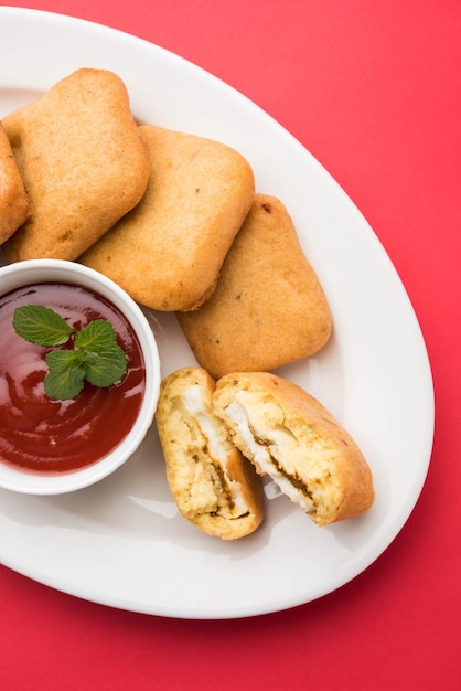 Paneer pakoras lub bhajji to gramowa mąka lub pikantne kostki twarogu w cieście besan. Podawany z keczupem pomidorowym w talerzu na kolorowym lub drewnianym tle. Selektywne skupienie