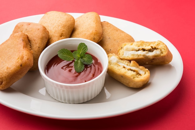 Paneer pakoras lub bhajji to gramowa mąka lub pikantne kostki twarogu w cieście besan. Podawany z keczupem pomidorowym w talerzu na kolorowym lub drewnianym tle. Selektywne skupienie