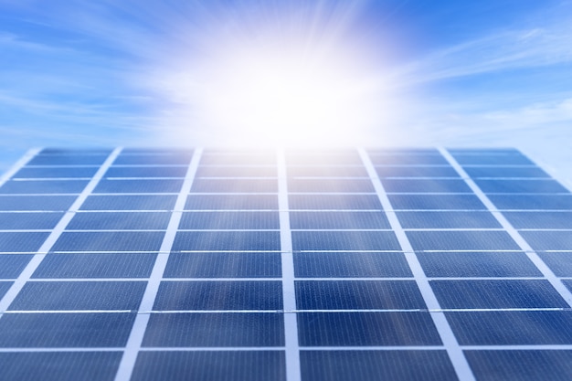 Zdjęcie panel energii słonecznej oświetlony światłem słonecznym na tle błękitnego nieba. szczegóły elektrowni słonecznej.