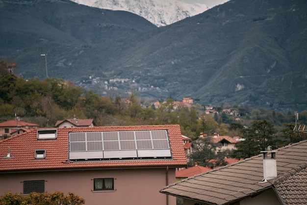 Panele słoneczne na dachu nowoczesnego domu Domek mieszkalny z niebieskim błyszczącym systemem paneli fotowoltaicznych na dachu Koncepcja ekologicznej produkcji odnawialnej zielonej energii Zrównoważony