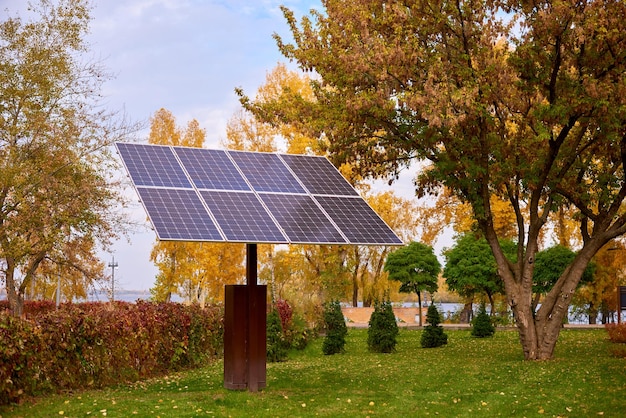 Panele słoneczne ochrony środowiska w parku miejskim w słoneczny jesienny dzień. żółte drzewa w jesiennym mieście