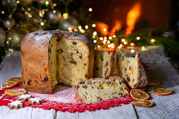 Zdjęcie panettone świąteczny tort na tle choinki i płonącego kominka