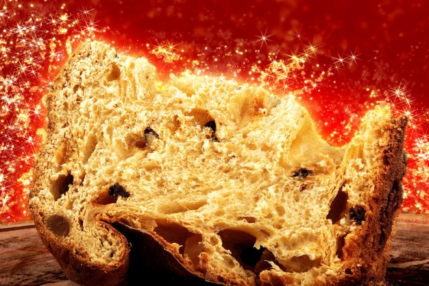 Panettone z pokrojonym tradycyjnym świątecznym jedzeniem z czerwonym tłem