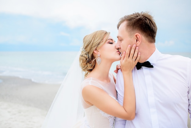 Panna młoda i pan młody całować każdą ofertę przetargu na plaży