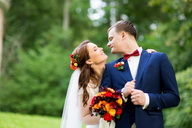 Panna młoda i pan młody stojący w parku