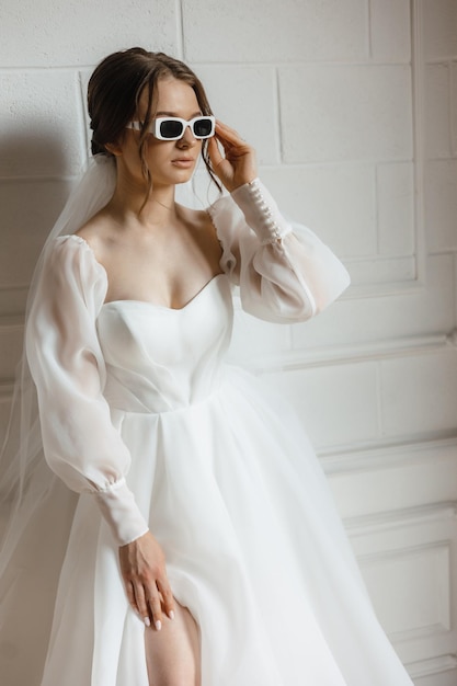 Panna młoda ubrana w suknię ślubną i okulary przeciwsłoneczne