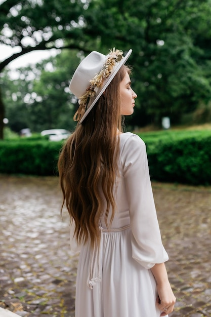 Panna młoda w kapeluszu i bukiecie Portret panny młodej w białej sukni Portret panny młodej Młoda dziewczyna w białej sukni ślubnej i kapeluszu z bukietem kwiatów