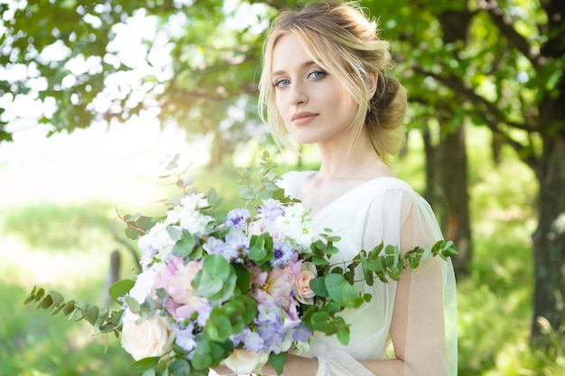 Panna Młoda z piękną florystyką w naturze wesele