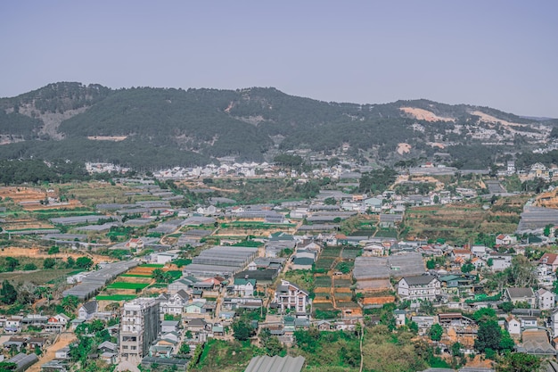 Panorama krajobraz Dalat miasto Langbian Plateau Wietnam Centralny region Highland Pola warzywne wiele domów Architektura pola uprawne szklarnia Tło górskie Zielony Szary zadymione zdjęcie