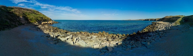 Zdjęcie panorama plaży z piaskiem i kamieniami w pobliżu morza czarnego w świetle zachodzącego słońca w bułgarii