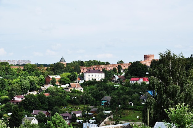 Panorama Smoleńska. Mur i wieża z czerwonej cegły. Małe drewniane domy w pobliżu murów Kremla.