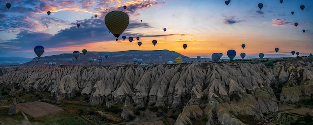 Zdjęcie panorama wschodu słońca słynnego krajobrazu kapadocji z dużą ilością balonów na ogrzane powietrze