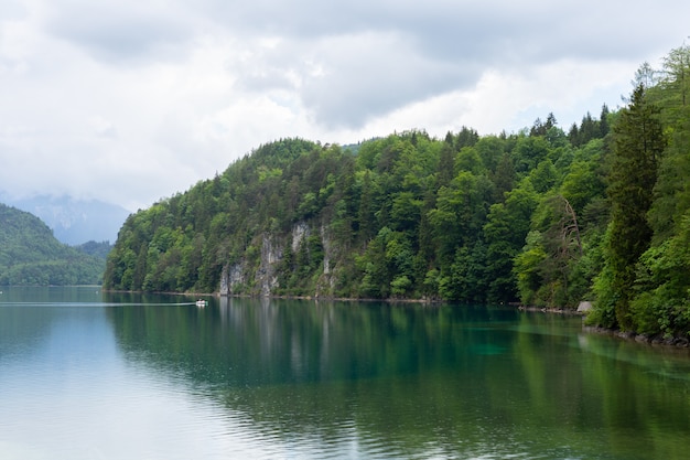 Panoramę jeziora Alpsee w otoczeniu gór Alp