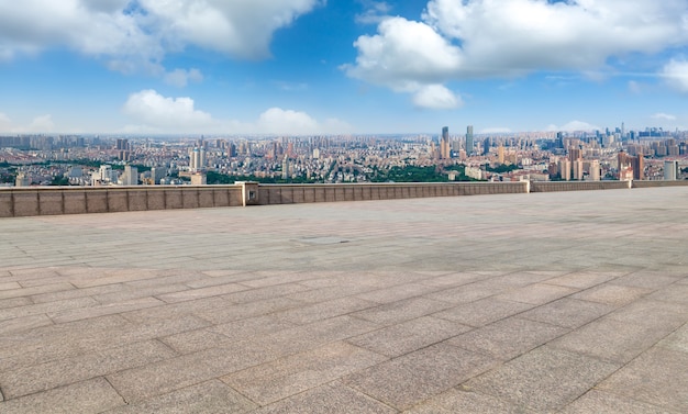 Panoramiczna panorama i puste kwadratowe płytki podłogowe z nowoczesnymi budynkami