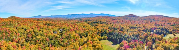 Panoramiczne anteny nad szczytowymi lasami jesiennymi w Vermont z błękitnym niebem