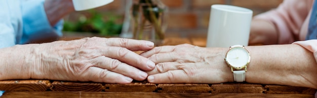 Zdjęcie panoramiczne ujęcie starszego mężczyzny dotykającego ręki emerytowanej kobiety