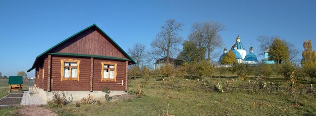 Zdjęcie panoramiczne zdjęcie starego wiejskiego domu i prawosławnego kościoła